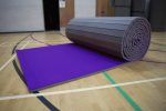 A picture of foldable purple AirTumble Roll Mats on the floor of a gymnasium.