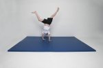 A child performing a cartwheel on an AirTumble lightweight mat, showcasing its cushioned surface for safe gymnastics practice.