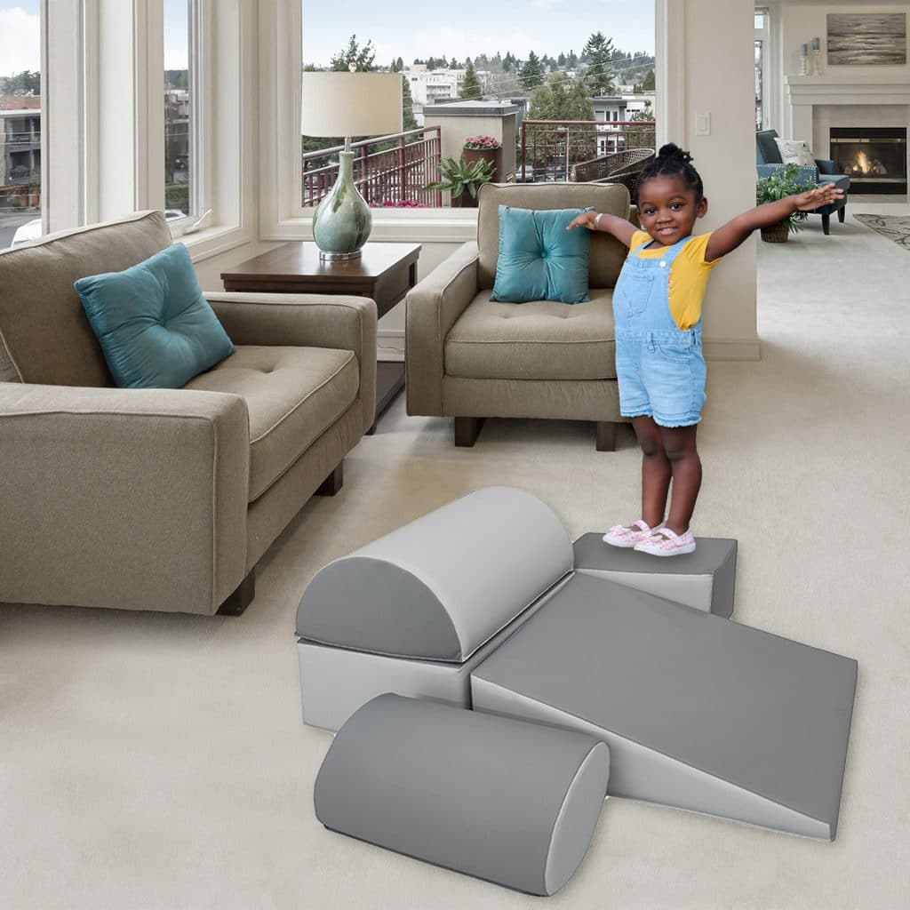 Toddler standing on safe foam play equipment in modern living room